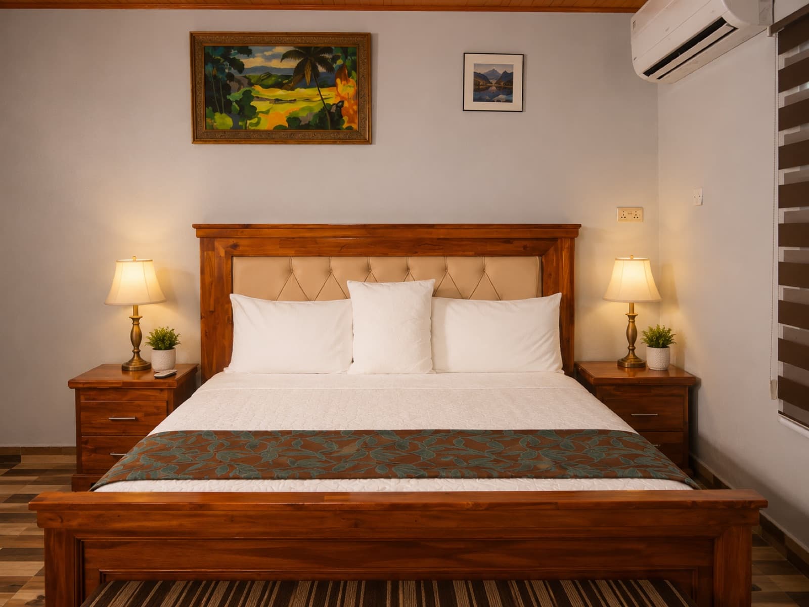 A spacious double room with a king bed and bedside lamps at JC Guest House