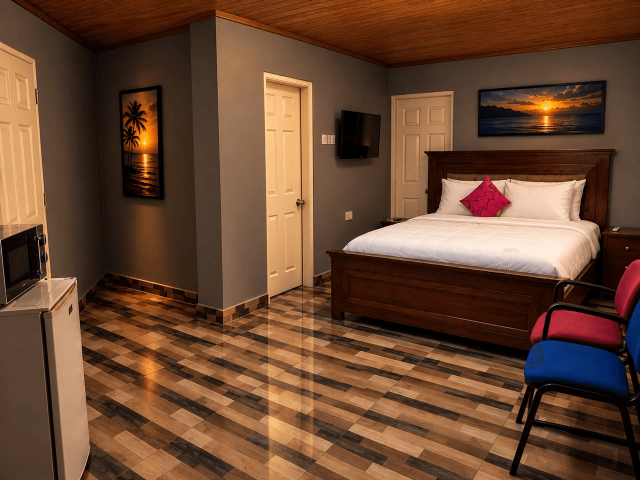 New Hampshire room with a wooden bed, sunset artwork, television, and seating at JC Guest House
