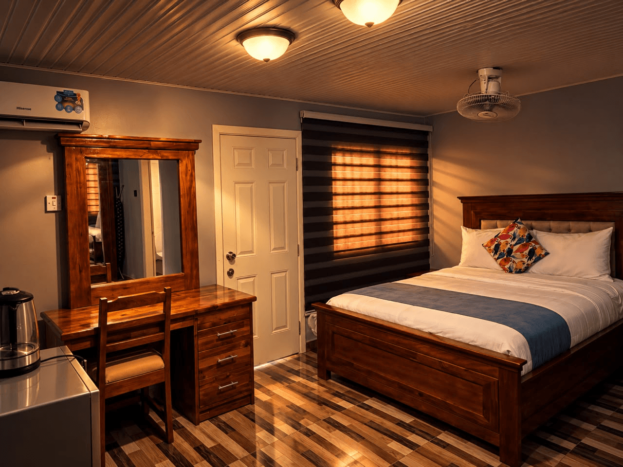 New York room with a wooden bed, blue bed runner, dressing table, and mirror at JC Guest House