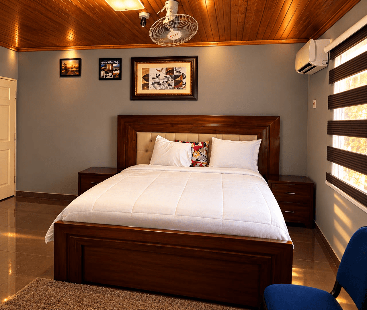 North Carolina room with a wooden bed, white bedding, framed artwork, and window blinds at JC Guest House