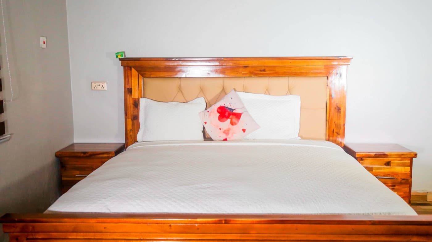 A double room with a king bed and matching nightstands at JC Guest House