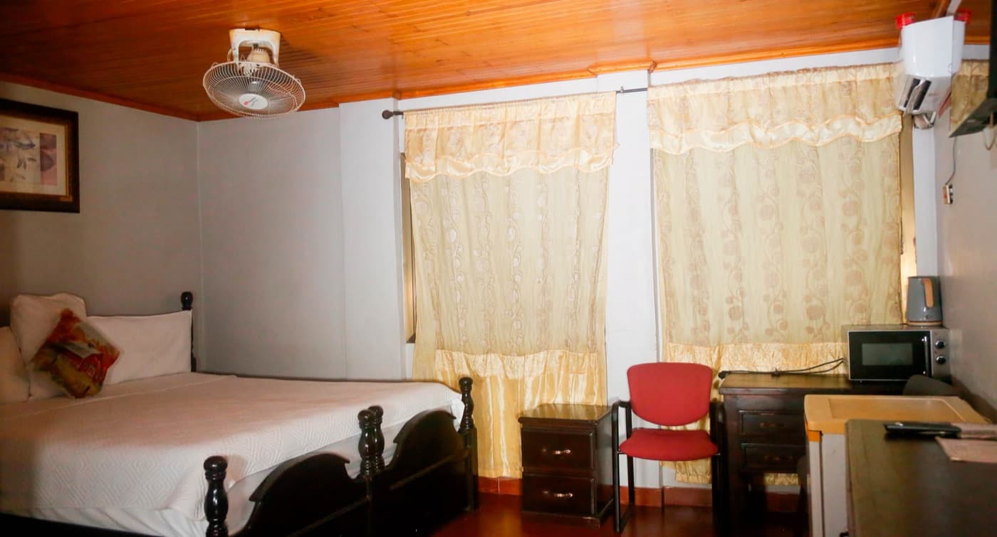 A single room with a work desk and kitchenette at JC Guest House