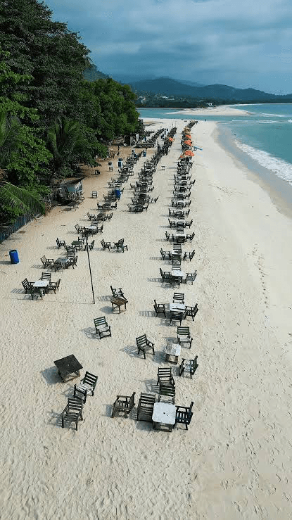 Rows of beach tables beside the sea at River Number Two